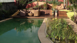 View over fresh water pool, landscaping and deck with outdoor furnitures