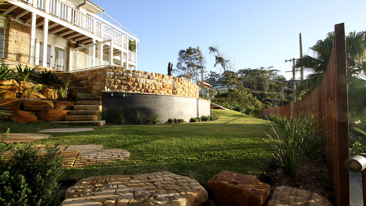 View from corner of garden over backyard landscaping, stonework and pool