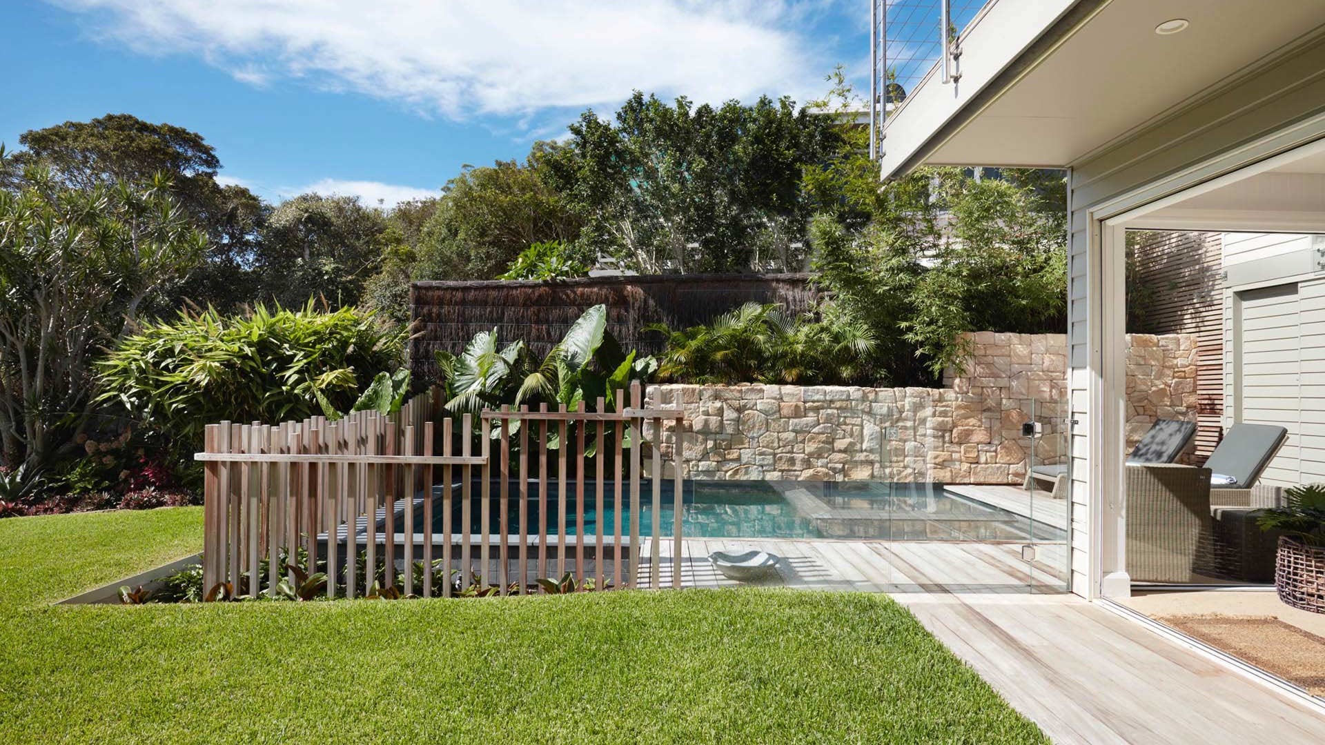 View from garden. View over lawn, part of the house and pool area.