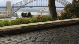 close up of stonework, garden with harbour bridge in the background